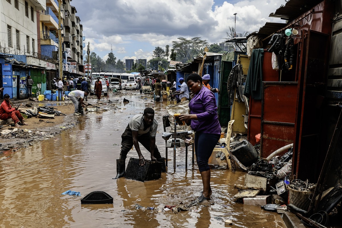 epa12801501 A Kenyan man tries to recover some of his auto spares from his damaged shop at Grogon garage area, known for automotive workshops and auto spares along the banks of the Nairobi River, in N ...