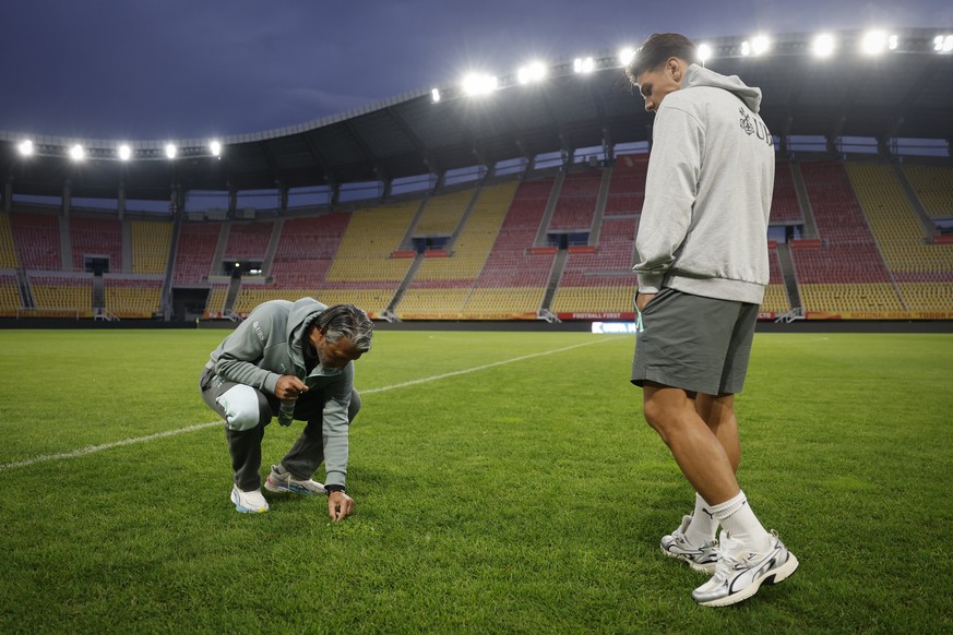 Switzerland's head coach Murat Yakin, left, and his player Ardon Jashari inspect the lawn in the stadium prior to a press conference one day ahead of the UEFA Nations League soccer match between  ...