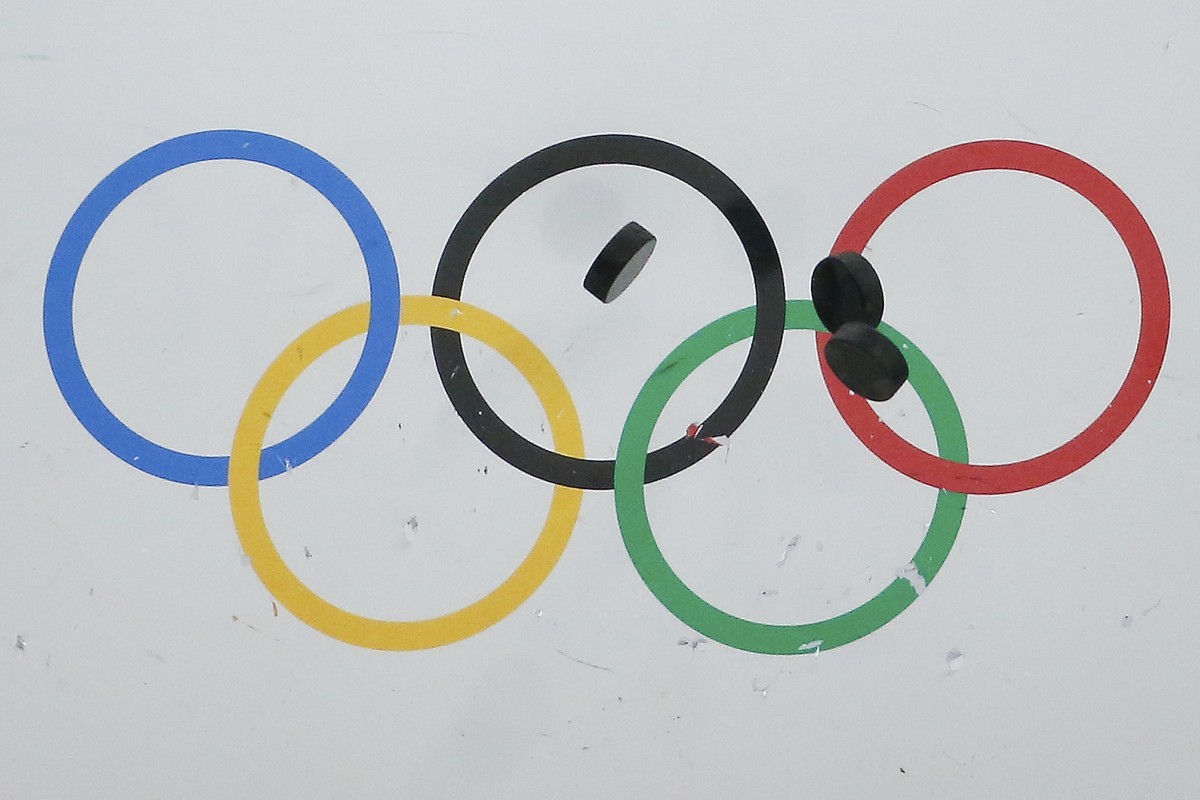 FILE - In this Feb. 22, 2014, file photo, hockey pucks bounce off the wall during the warm up session before the USA vs Finland men's bronze medal ice hockey game at the 2014 Winter Olympics in S ...