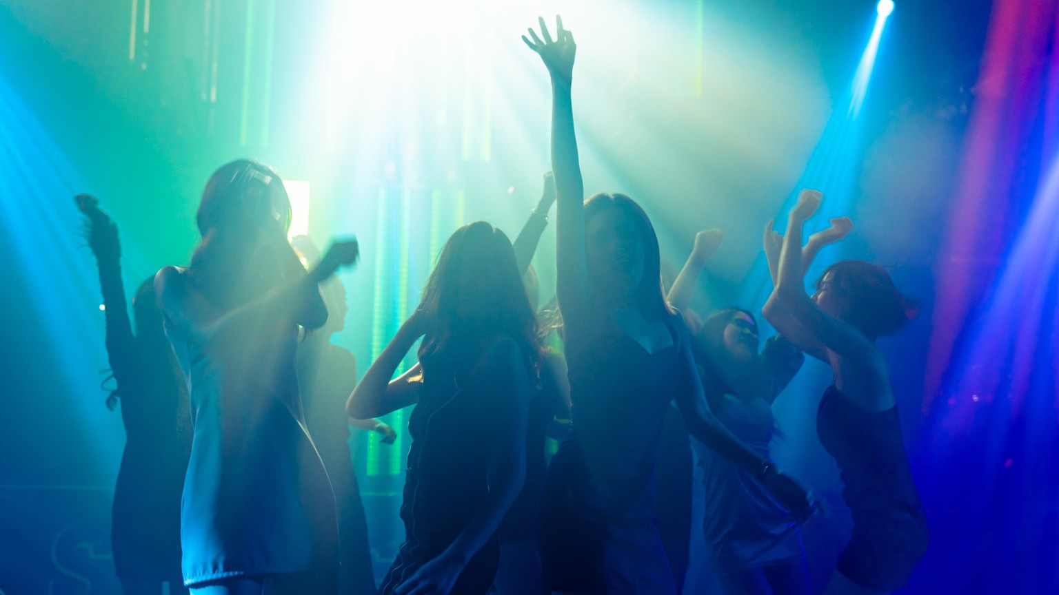 Silhouette Bild von Menschen tanzen in Disco Nachtclub zu Musik von DJ auf der Bühne . Neue Jahr Nacht Party und Nachtleben Konzept .