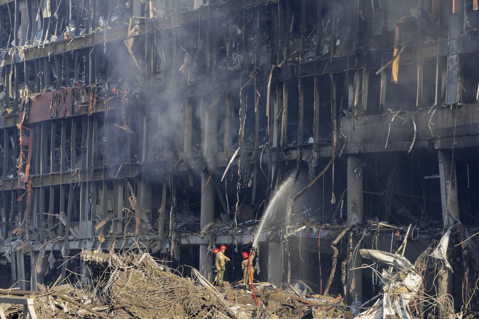 Ukrainian firefighters extinguish smoke after shelling of a shopping center, in Kyiv, Ukraine, Monday, March 21, 2022. Eight people were killed in the attack. (AP Photo/ (AP Photo/Efrem Lukatsky)