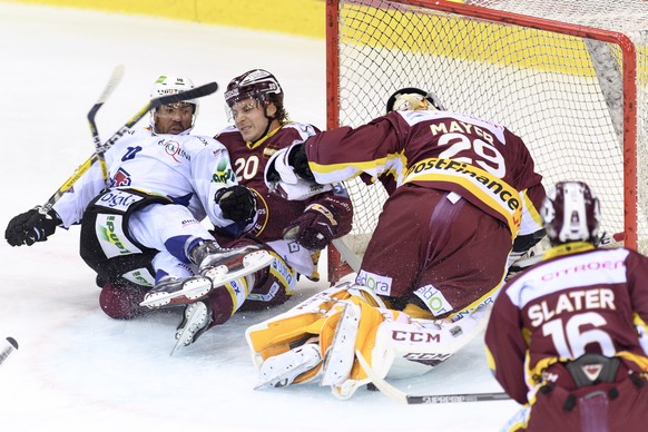 Le joueur biennois, Robbie Earl, gauche, a la lutte pour le puck avec le joueur Genevois, Johan Fransson, centre, devant le gardien genevoi, Robert Mayer, droite, lors du match du championnat suisse d ...