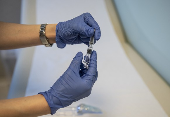 epa08731198 A health worker shows Sinovac Biotech&#039;s COVID-19 vaccine during the 3rd phase trials at the Acibadem Hospital in Istanbul, Turkey, 09 October 2020. EPA/ERDEM SAHIN