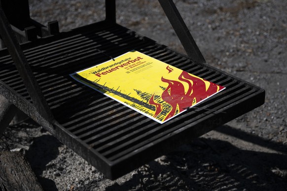 Auf einer Grillstelle auf dem Kaeferberg, macht ein Plakat auf die Waldbrandgefahr und das Feuerverbot im Wald und Waldesnaehe aufmerksam, am Donnerstag, 8. Juli 2026, in Zuerich. In weiten Teilen der ...