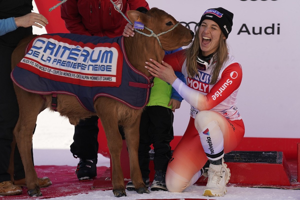 The winner Switzerland's Jasmine Flury with the cow she was presented after an alpine ski, women's World Cup downhill race, in Val d'Isere, France, Saturday, Dec. 16, 2023. (AP Photo/Gi ...