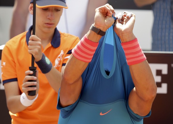 Rafael Nadal of Spain changes his shirt during the second round match against Marsel Ilhan of Turkey at the Rome Open tennis tournament in Rome, Italy May 13, 2015. REUTERS/Max Rossi