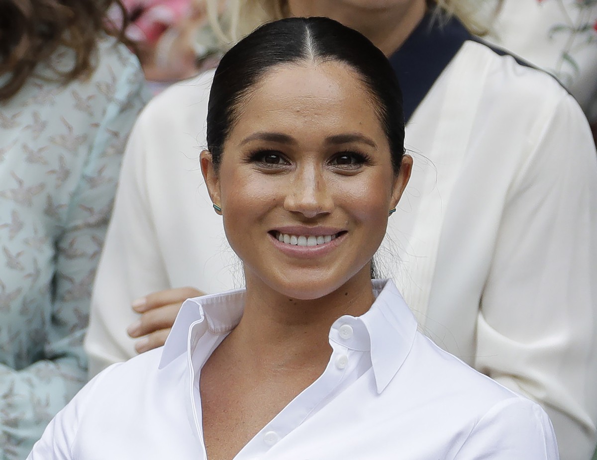 FILE - In this July 13, 2019 file photo, Kate, Meghan, Duchess of Sussex smiles while sitting in the Royal Box on Centre Court to watch the women's singles final match between Serena Williams, of ...
