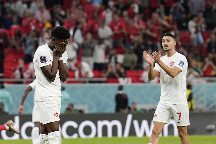 Canada's Alphonso Davies, left, reacts after missing a scoring chance scores on a penalty kick during the World Cup group F soccer match between Belgium and Canada, at the Ahmad Bin Ali Stadium in Doh ...