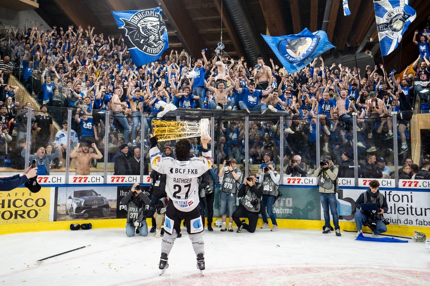 Die Fribourger Spieler mit Yannick Rathgeb feiern den Meistertitel mit dem Pokal nach ihrem Sieg gegen Davos in der Verlaengerung im siebten Eishockey Playoff Finalspiel der National League zwischen H ...
