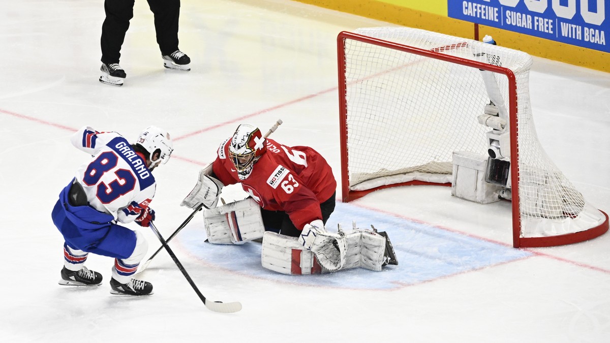 epa12135306 Switzerland's goalkeeper Leonardo Genoni (#63) saves a penalty shot from USA's Conor Garland (#83) during the IIHF Ice Hockey World Championship final match between Switzerland a ...