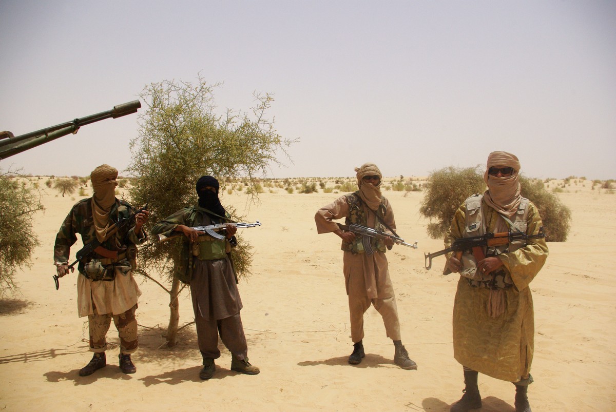 FILE - In this Tuesday, April 24, 2012 file photo, fighters from Islamist group Ansar Dine stand guard during a hostage handover, in the desert outside Timbuktu, Mali. The movie “Timbuktu” , an Oscar  ...