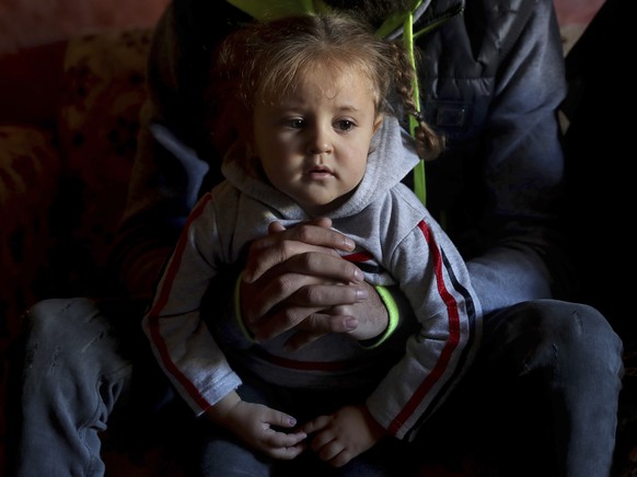 Ziad Khaled Hilweh, who tried to migrate to Europe with his family, speaks during an interview as his daughter Jana 2 year-old sits on his lap, at his parents house in the northern city of Tripoli, Le ...