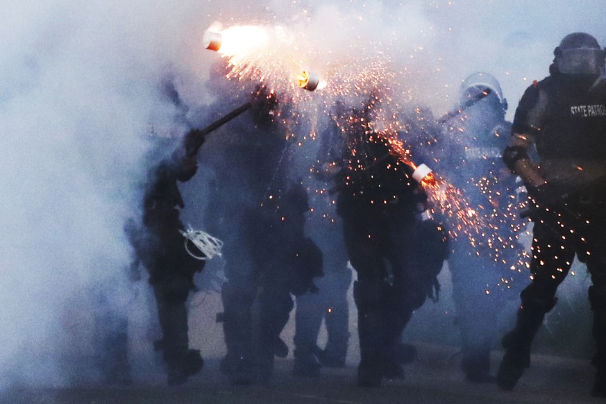 Police clear an area after curfew Saturday, May 30, 2020, in Minneapolis. Protests continued following the death of George Floyd, who died after being restrained by Minneapolis police officers on Memo ...