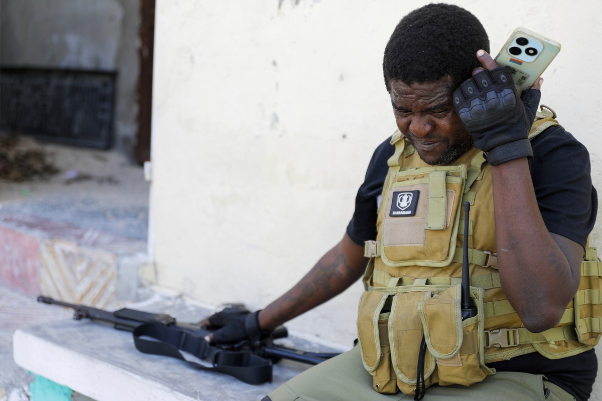 Barbecue, the leader of the "G9 and Family" gang, listens to his cell phone after addressing journalists in the Delmas 6 neighborhood of Port-au-Prince in Port-au-Prince, Haiti, Tuesday, Mar ...