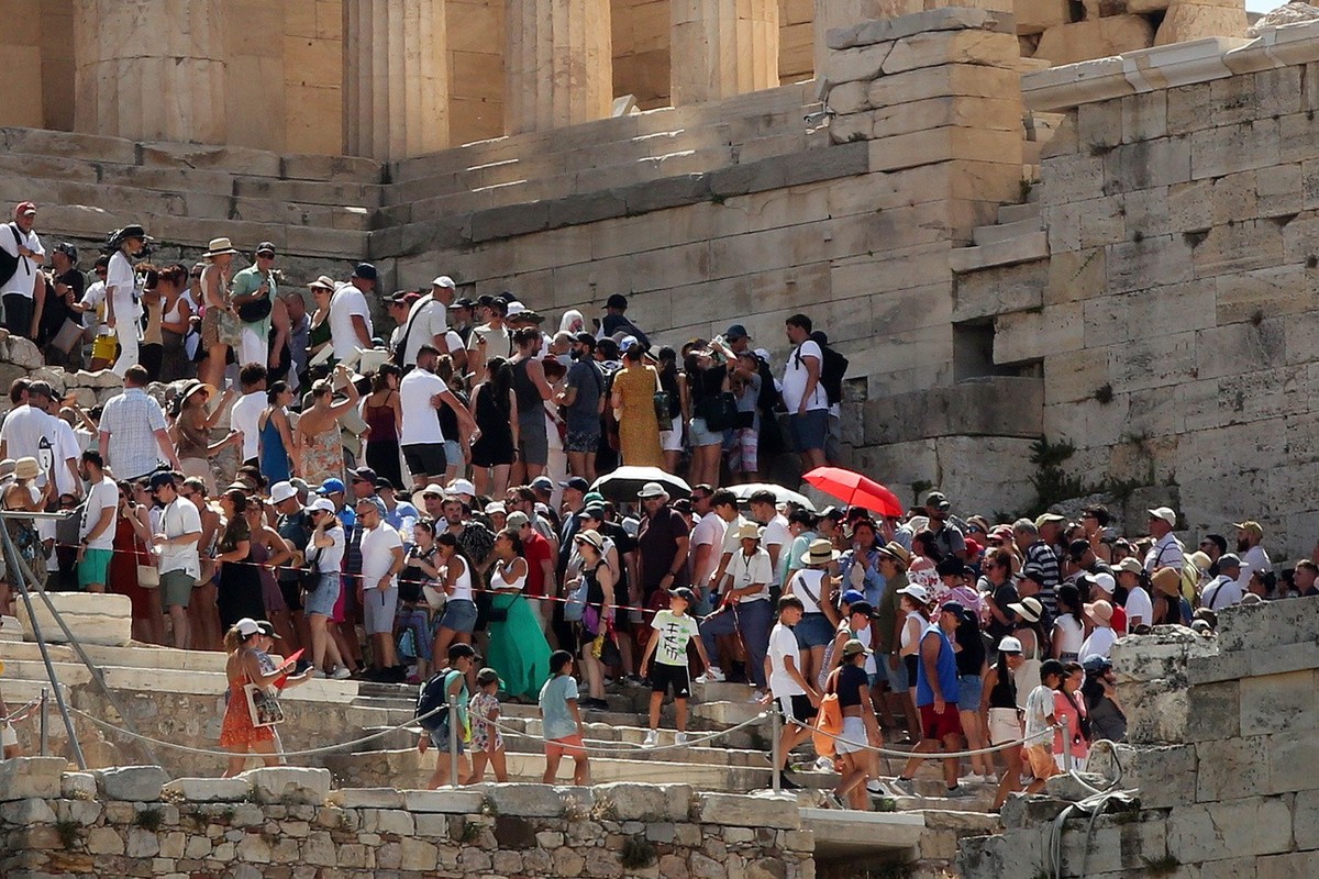 epa10745427 Tourists visit Acropolis amid high temperatures in Athens, Greece, 14 July 2023. Archaeological sites in Athens have closed for the public at 12.00 because of the heat. Extremely high temp ...