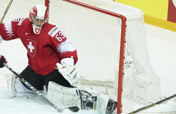 Leonardo Genoni of Switzerland, left, blocks a shot during the Ice Hockey World Championship quaterfinal match between Switzerland and Germany at the Olympic Sports Center in Riga, Latvia, Thursday, J ...