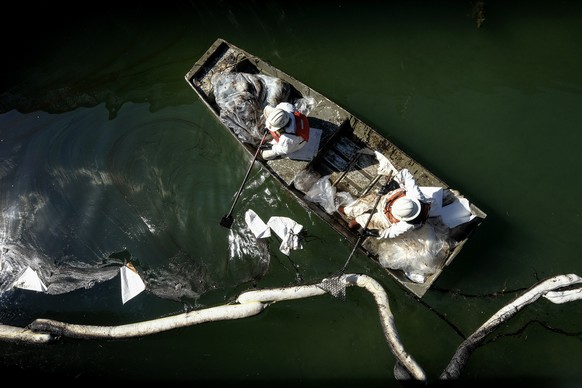 Workers in protective suits clean oil in an inlet leading to the Wetlands Talbert Marsh after an oil spill in Huntington Beach, Calif., on Tuesday, Oct. 5, 2021. A major oil spill off the coast of Sou ...
