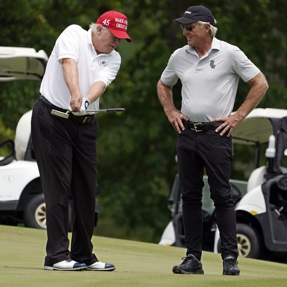 Former President Donald Trump, left, talks with LIV Golf CEO Greg Norman on a green during the pro-am round of the Bedminster Invitational LIV Golf tournament in Bedminster, NJ., Thursday, July 28, 20 ...