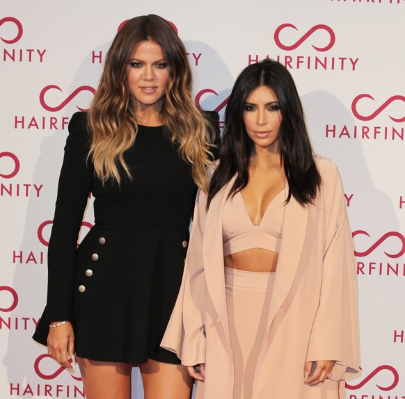 Kim and Khloe Kardashian, left, pose for photographers on her arrival at the Hairfinity party in central London, Saturday, Nov. 8, 2014. (Photo by Grant Pollard/Invision/AP)