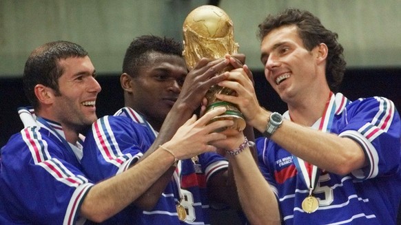 FILE - In this Sunday, July 12, 1998 file photo, French teammates from left, Zinedine Zidane, Marcel Desailly and Laurent Blanc hold the soccer World Cup after France defeated Brazil 3-0 in the World  ...