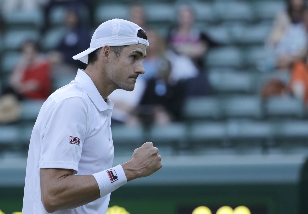 John Isner of the United States celebrates winning a point during his men's quarterfinals match against Canada's Milos Raonic, at the Wimbledon Tennis Championships, in London, Wednesday Jul ...
