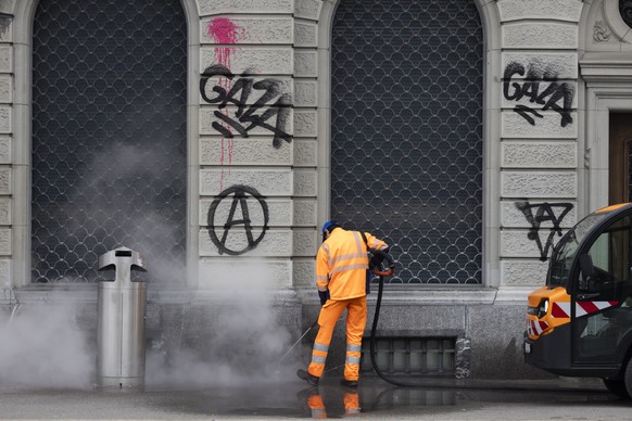 Ein Mitarbeiter der Stadtreinigung reinigt das Trottoir vor der Valiant Bank mit Wasserdampf, am Tag nach der nicht bewilligten Demonstration fuer Gaza, am Sonntag, 12. Oktober 2025 in Bern. Bei der D ...