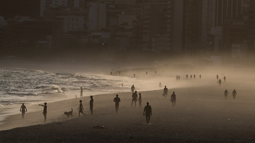 epaselect epa08339899 Brazilians and tourists walk at Ipanema beach, in Rio de Janeiro, Brazil, 02 April 2020. The late afternoon took some people to the beach despite the quarantine that governs seve ...