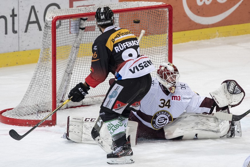 Berns Thomas Ruefenacht, links, im Duell mit Servettes Torhueter Gauthier Descloux im Eishockey Meisterschaftsspiel der National League zwischen dem SC Bern und Genf-Servette HC, am Samstag, 11. Janua ...