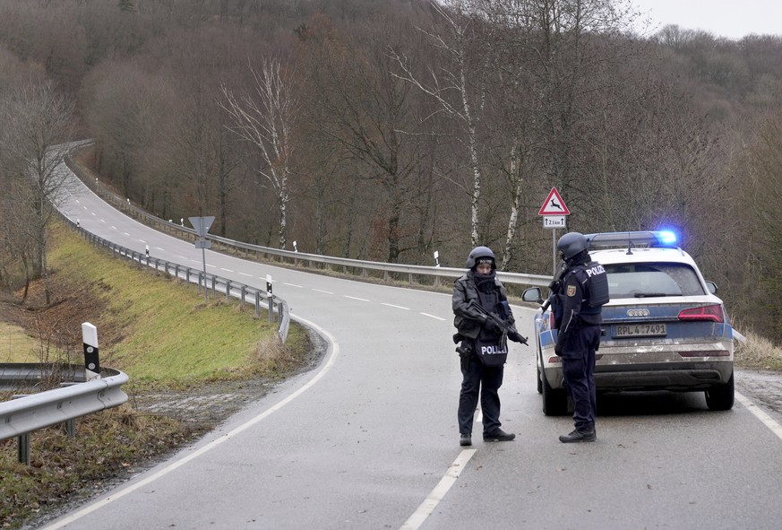 Police officers block the access road to the scene where two police officers were shot during a traffic stop near Kusel, Germany, Monday, Jan. 31, 2022. Police say two officers have been shot dead whi ...