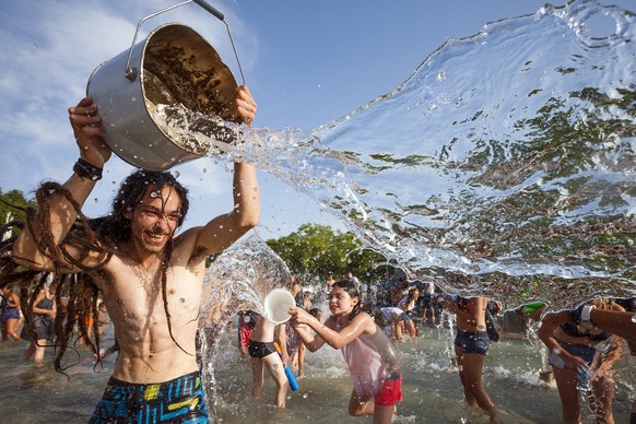 People throw water at each other during a 10-minute long water battle flash mob in Lausanne, Switzerland, Friday, July 3, 2015. The temperatures have been reaching over 35 degrees Celsius for several  ...