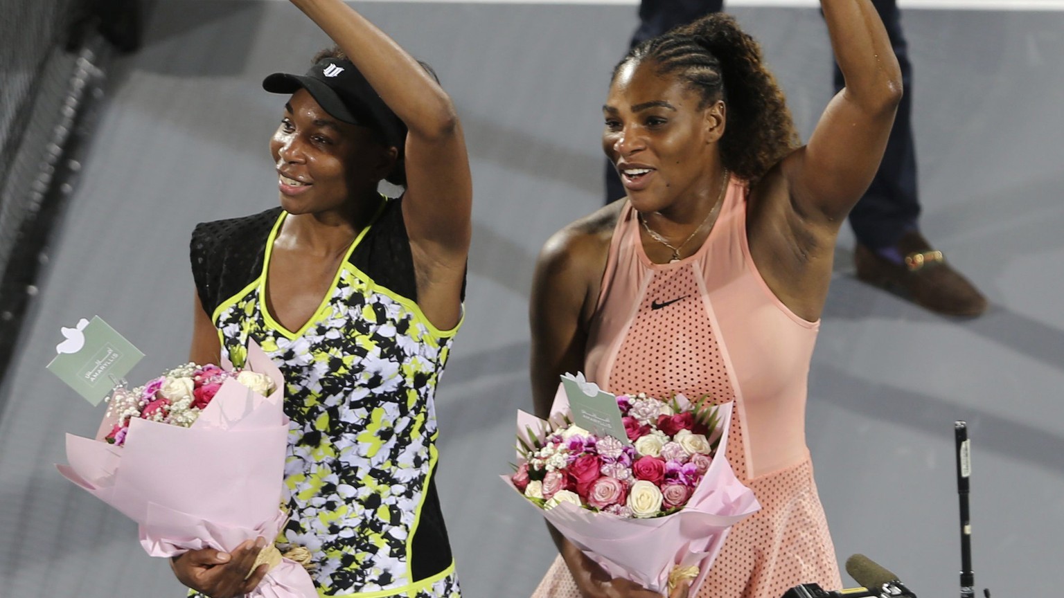 FILE - Venus Williams, left, celebrates winning against her sister Serena, right, after a match on the opening day of the Mubadala World Tennis Championship in Abu Dhabi, United Arab Emirates, Dec. 27 ...