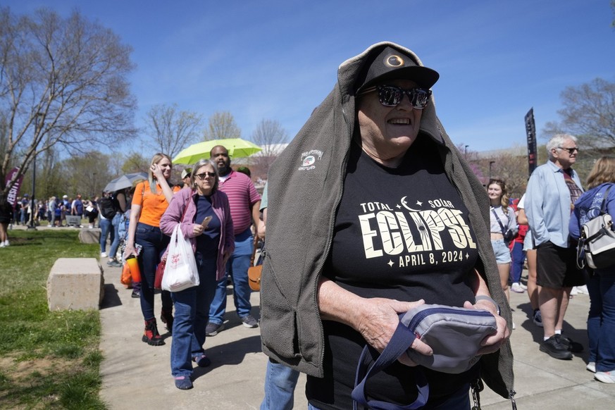 Liz Barker stands in line with other spectators to enter Saluki Stadium and watch the total solar eclipse Monday, April 8, 2024, in Carbondale, Ill. (AP Photo/Jeff Roberson)