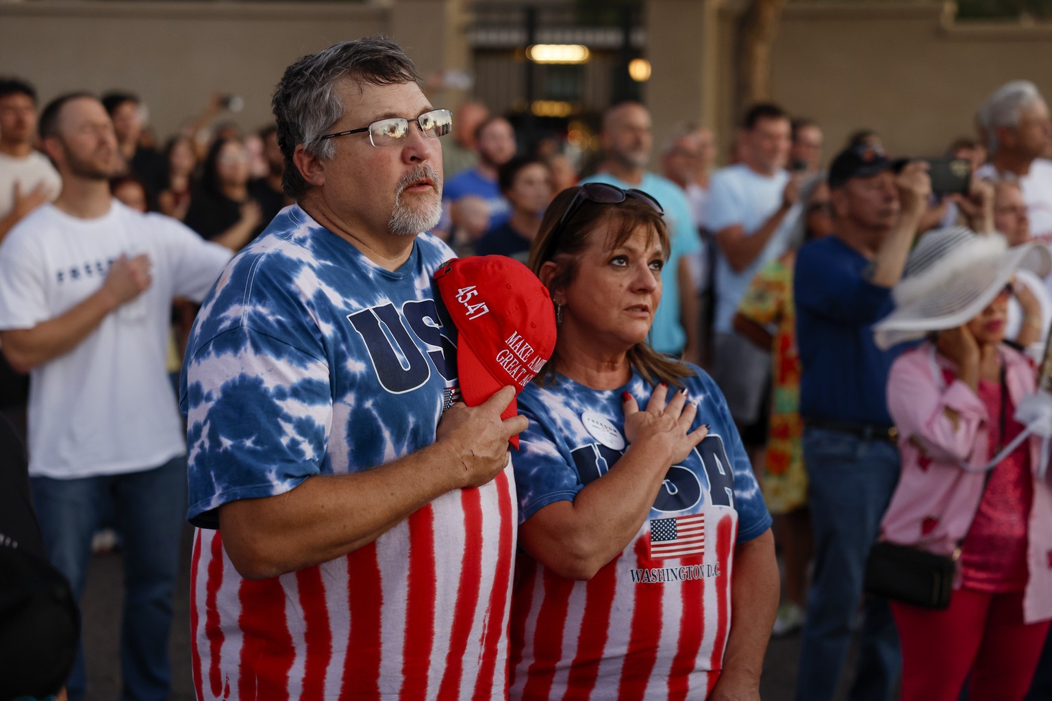 epa12394353 Two people recite the Pledge of Allegiance at makeshift memorial outside of the Turning Point USA headquarters, after conservative political activist Charlie Kirk was killed on 10 Septembe ...