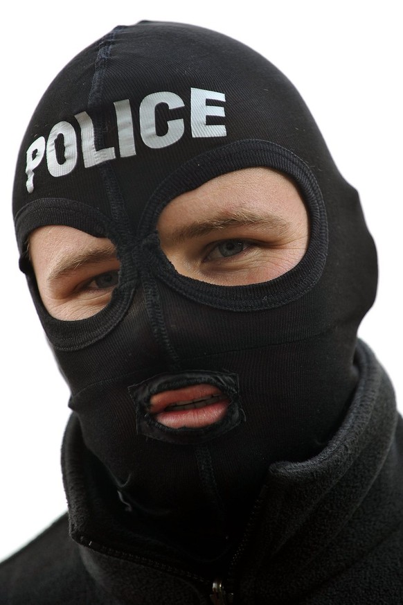 Un agent de Police du GRIF Groupe Intervention de la Police Cantonale Fribourgeoise arme, simulant une attaque, lors de la journee de celebration de ses 20 ans d'existence, ce lundi 17 novembre 2008 a Fribourg, a organise une visite pour la presse, avec un excerice pratique de ses participants, consistant a la vitesse d'escalade du Pont de Perolles. (KEYSTONE/Sandro Campardo)