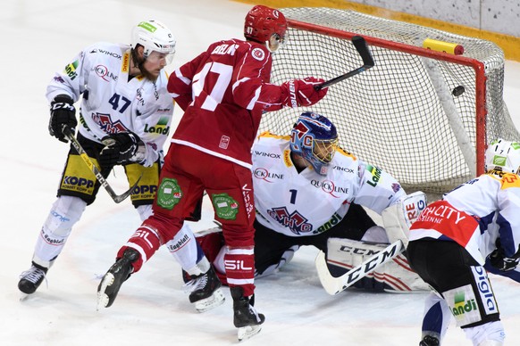 Le gardien biennois Jonas Hiller, droite, encaisse le premier but a cote de son coequipier le defenseur Marco Maurer, gauche, et de l&#039;attaquant lausannois Philippe Schelling, centre, lors du matc ...