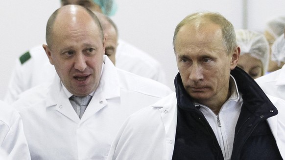 FILE - Businessman Yevgeny Prigozhin, left, shows Russian President Vladimir Putin, around his factory which produces school meals, outside St. Petersburg, Russia on Monday, Sept. 20, 2010. The fighti ...