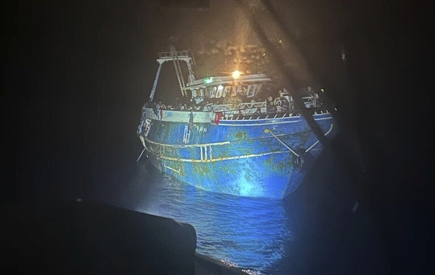 This undated handout photo, issued by Greece's coast guard on June 15, 2023, shows a large number of people covering practically every free deck on a capsized fishing boat after ...