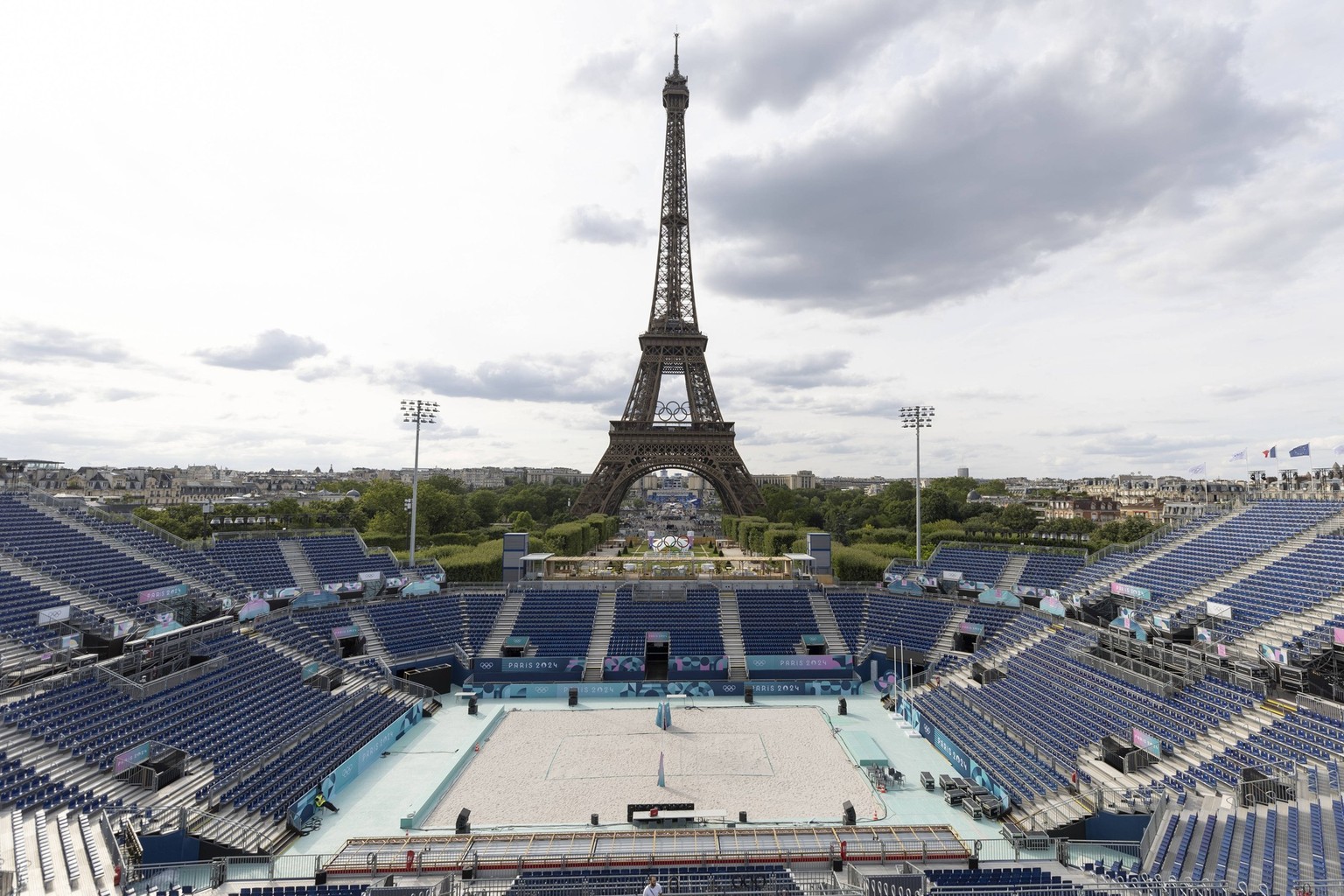 Der Eiffelturm mit den olympischen Ringen, Blick ueber das Beachvolleyball Stadion im Parc du Champ de Mars. Vorbereitungen in Paris auf die Olympischen Spiele, am 17.07.2024, Olympische Spiele Paris  ...