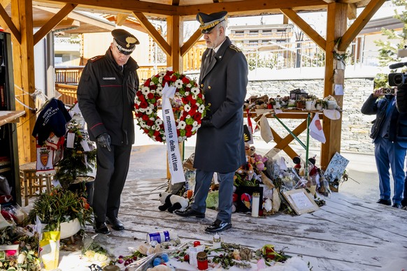 Two Italian police officers lay a wreath on behalf of the Italian Embassy in Switzerland to honor the victims of the deadly fire at the bar "Le Constellation", in Crans-Montana, Switzerland, ...