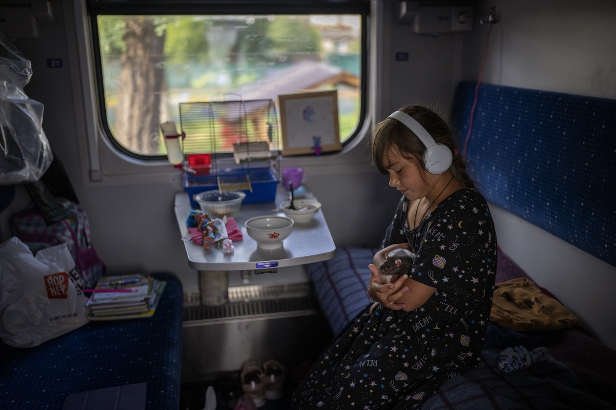Olga, 9, plays with her pet rat Pica in a converted train carriage which serves as a temporary shelter for her family and others who lost their homes in the war, in Irpin, Ukraine, Thursday, Sept. 1,  ...