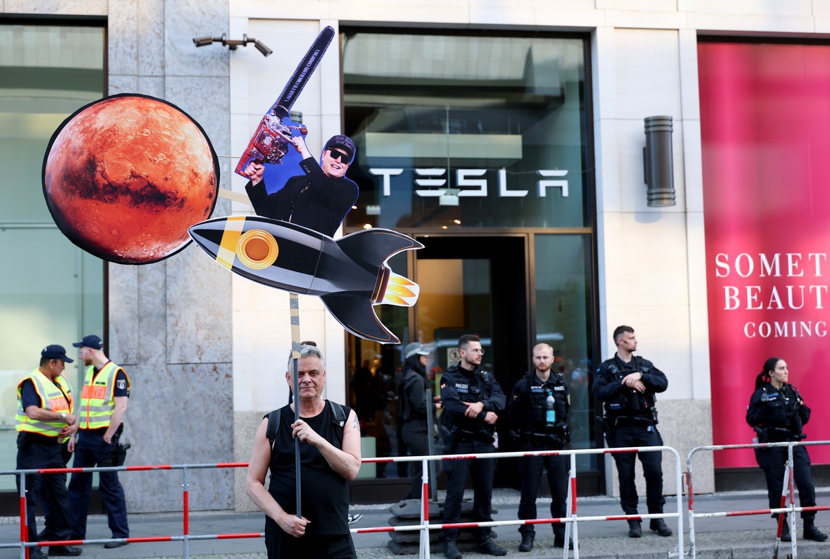 epa12065546 An activist from the New Generation holds a paper figure symbolizing Elon Musk on a rocket heading to Mars during a protest in front of a Tesla store in Berlin, Germany, 30 April 2025. Pro ...