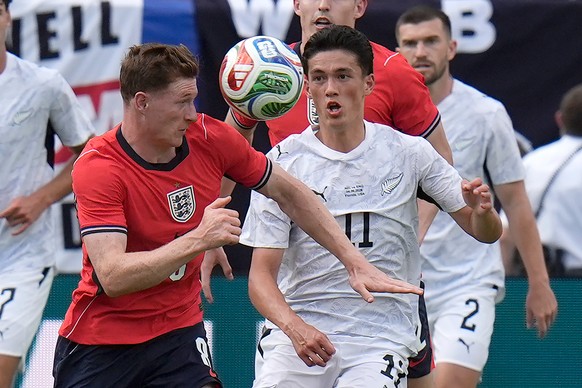 England midfielder Elliot Anderson heads the ball away from New Zealand forward Elijah Just (11) during the second half of an international friendly soccer match Saturday, June 6, 2026, in Tampa, Fla. ...