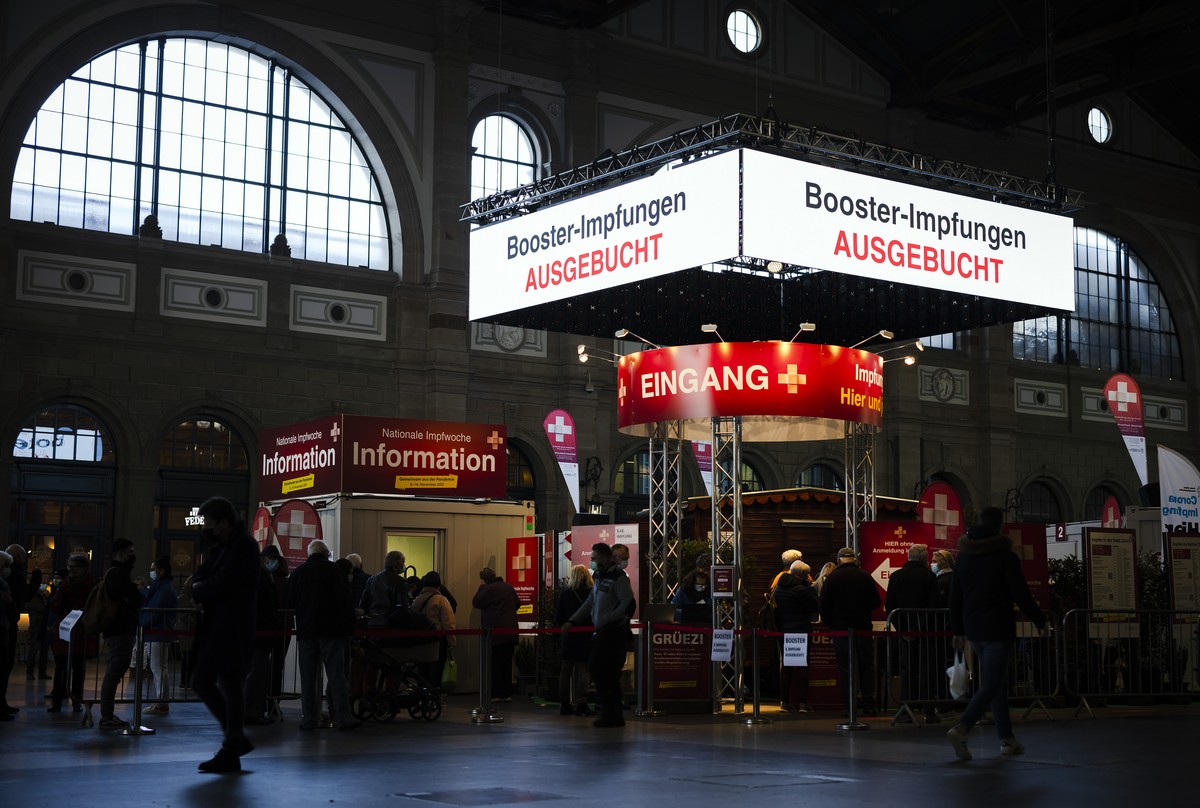 Eine digitale Anzeigetafel zeigt "Booster-Impfung Ausgebucht" an waehrend Leute in der Schlange stehen, beim Impfdorf in der grossen Halle des Hauptbahnhofs Zuerich, am Dienstag, 9. November ...