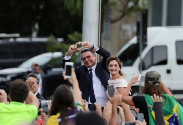 epa07257324 Brazilian President-elect Jair Bolsonaro (C-L) and wife Michele (C-R) head to the Planalto Palace for a ceremony in which Bolsonaro will receive the presidential band from his predecessor, ...
