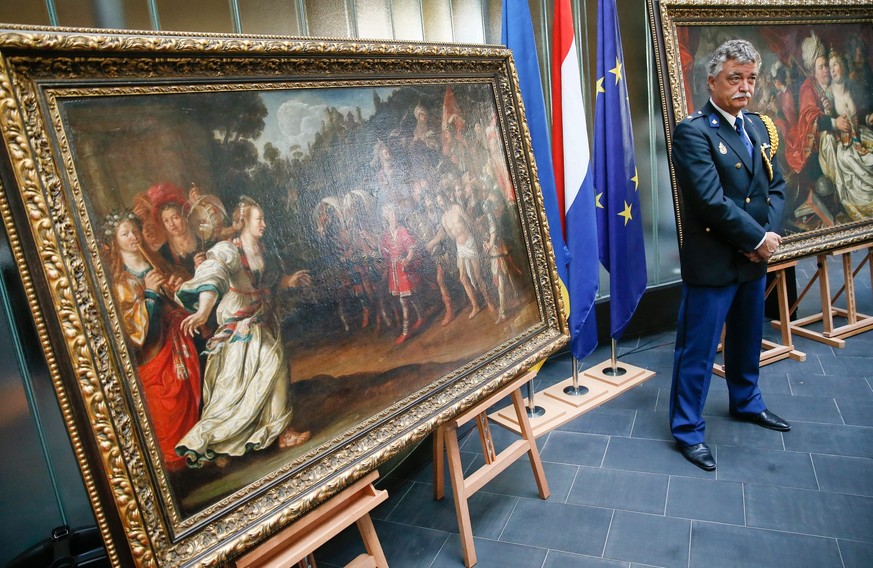 epa05542538 A man dressed uniform stands near of paintings during the handing ceremony of five paintings to the Dutch Westfries Museum, in Kiev, Ukraine, 16 September 2016. A total of 24 artworks were ...