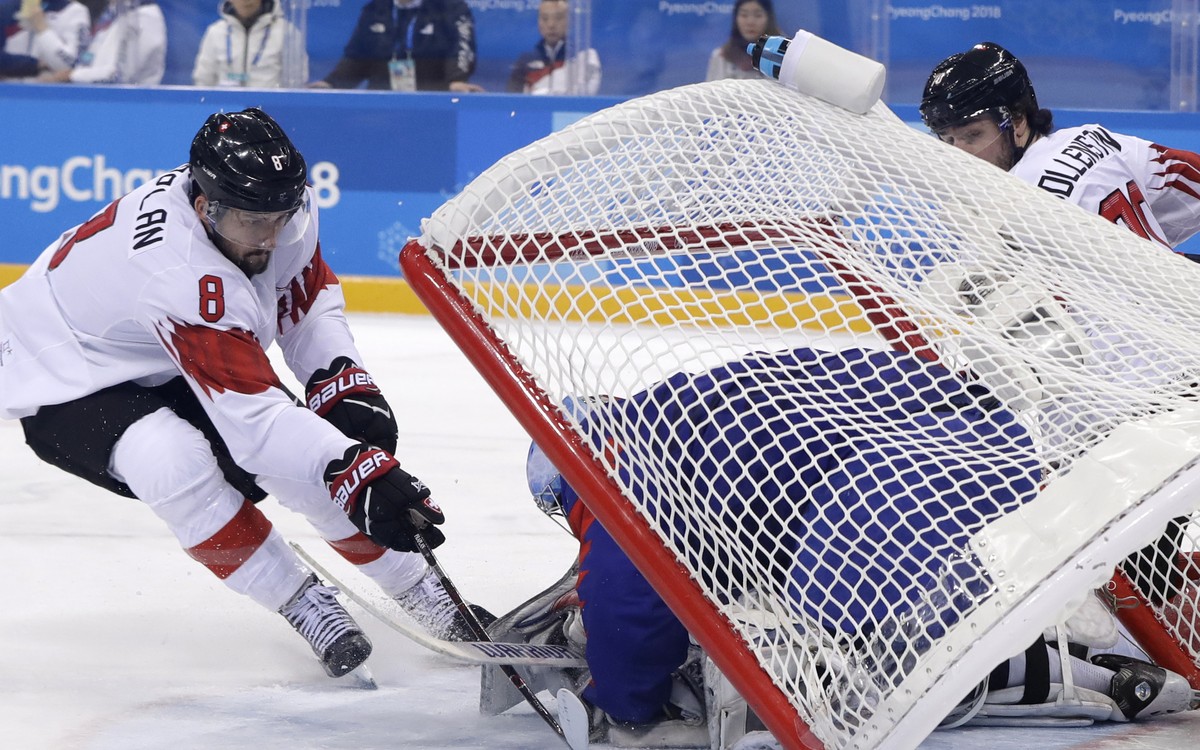 The goal falls as goalie Matt Dalton (1), of South Korea, makes a save against Vincent Praplan (8), of Switzerland, during the first period of the preliminary round of the men's hockey game at th ...