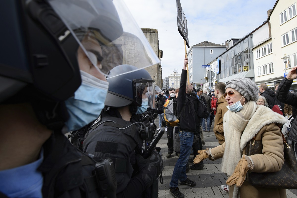 A woman speaks to police officers on duty at a rally under the motto "Free citizens Kassel - basic rights and democracy" in Kassel, Germany, Saturday, March 20, 2021. According to police, se ...