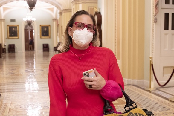 epa09696202 Democratic Senator from Arizona Kyrsten Sinema walks outside the Senate chamber before a procedural vote on voting rights legislation in the Senate, on Capitiol Hill in Washington, DC, USA ...