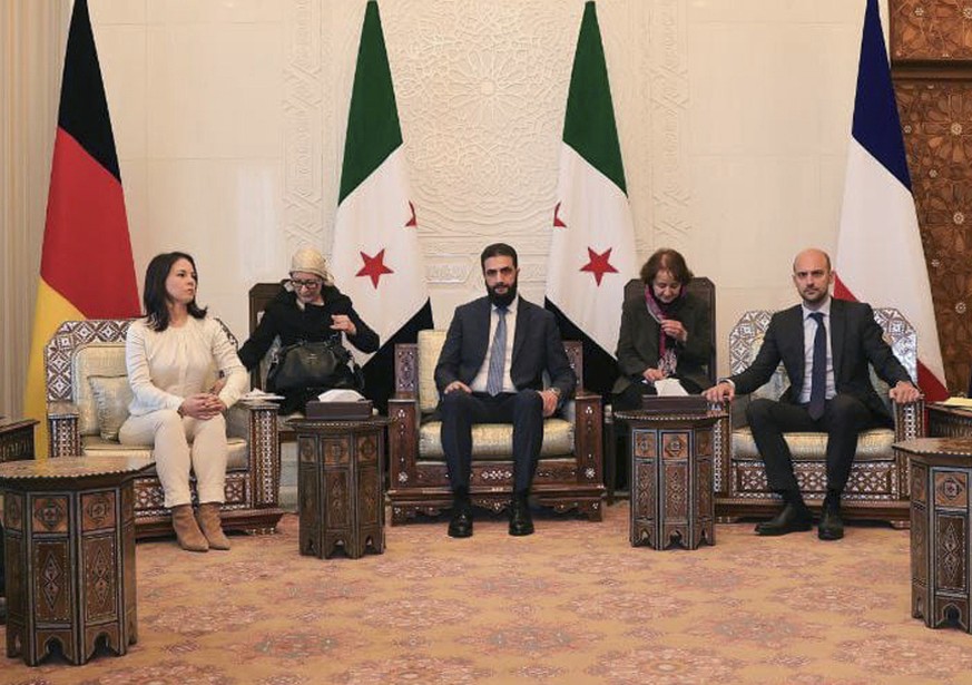 In this photo released by the Syrian official news agency SANA, Syria&#039;s de facto leader Ahmad al-Sharaa, formerly known as Abu Mohammed al-Golani, center, meets with German foreign minister, Anna ...