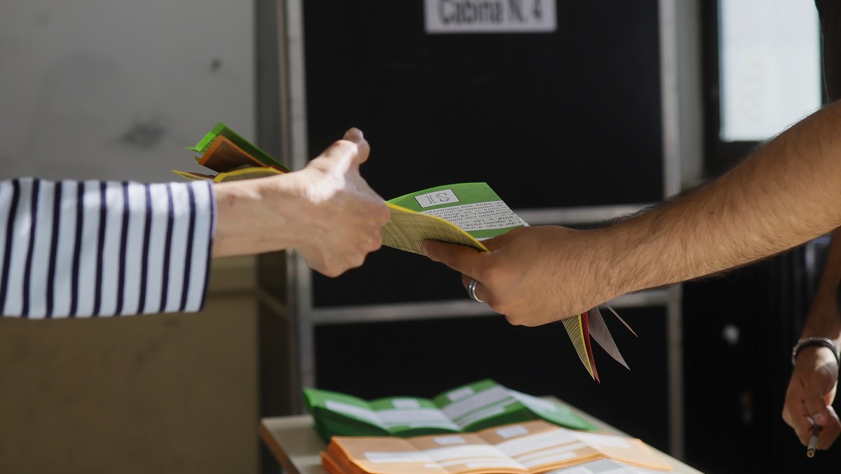 Ballot papers are handed over to a citizen, left, to vote on referendums on citizenship and job protections, at a polling station in Rome, Sunday, June 8, 2025. (Cecilia Fabiano/LaPresse via AP)
Italy ...
